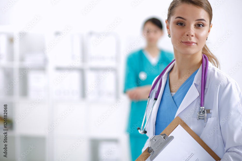 Woman doctor standing with folder at hospital Woman doctor standing with folder at hospital