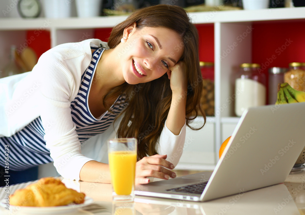Young woman sitting near desk in the kitchen Young woman sitting near desk in the kitchen