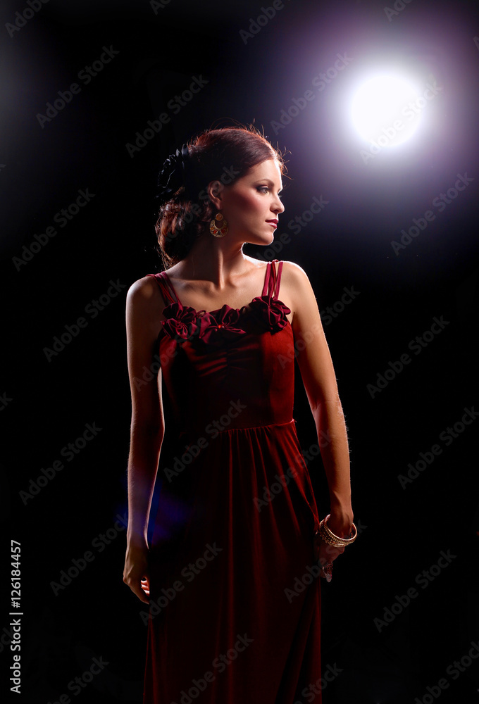 Fototapeta premium Young woman wearing a red dress standing