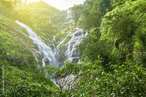 Heart-shaped waterfall in sunlight. Pitugro waterfall is situated in deep forest of Umpang, Thailand. photo