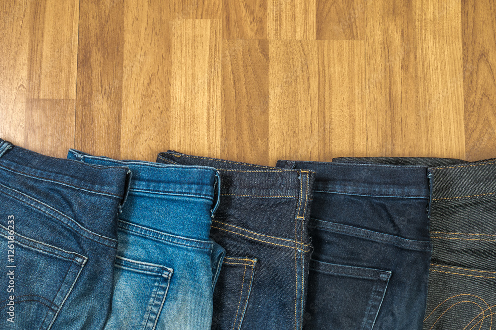 Blue jeans on a brown wooden background and Blue jeans denim Col Blue jeans on a brown wooden background and Blue jeans denim Col