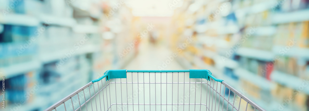 Supermarket aisle with red shopping cart - obrazy, fototapety, plakaty 