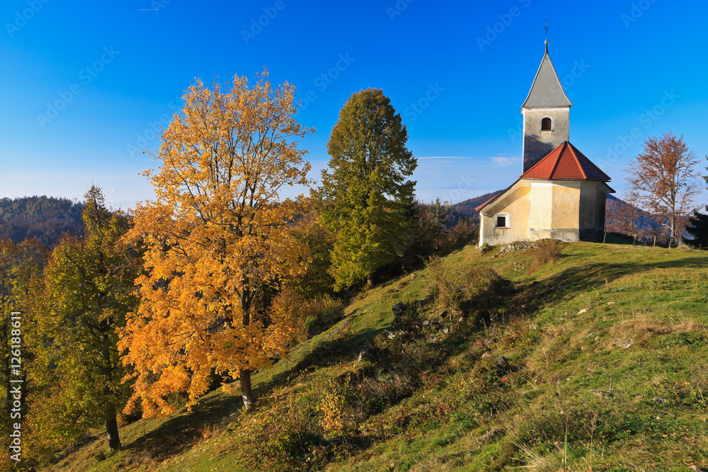 St. Ahacij church and autumn colored trees near ?rnivec above Kamnik, Slovenia