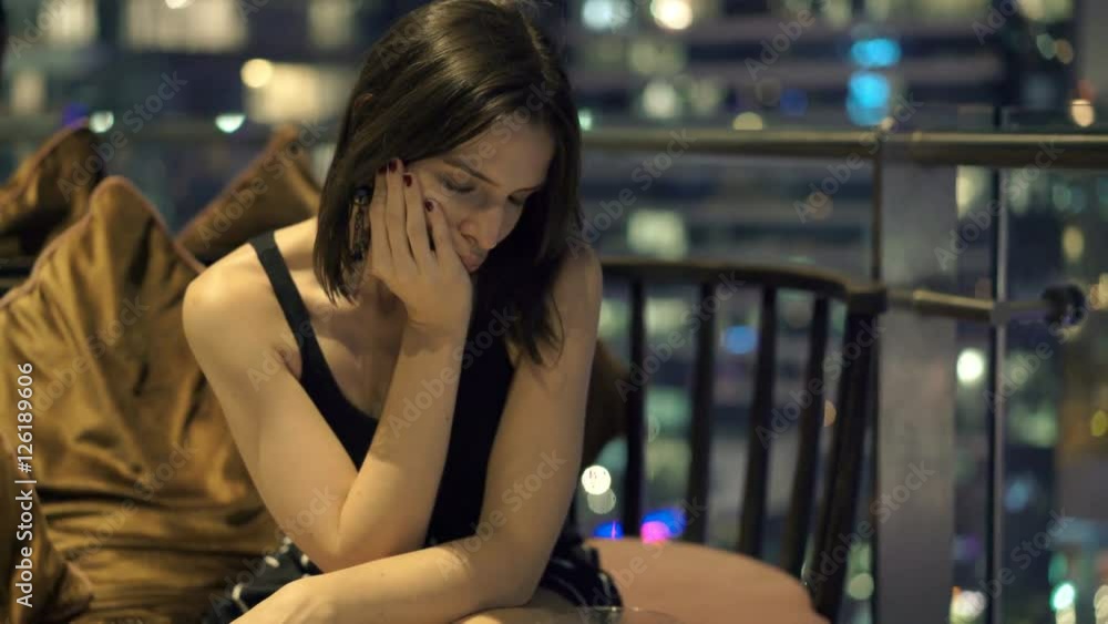 Sad, unhappy woman sitting on terrace in cafe at night
Sad, unhappy woman sitting on terrace in cafe at night