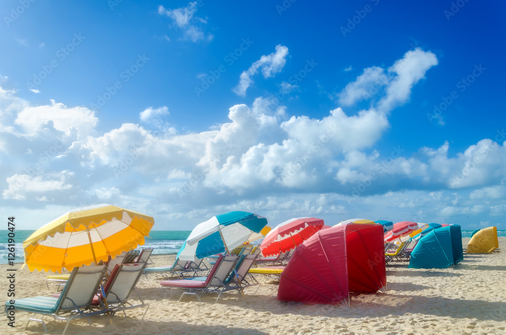 Colorful Beach umbrellas/parasols and cabanas near ocean Colorful Beach umbrellas/parasols and cabanas near ocean