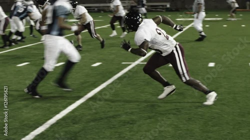 Close up of a football running back getting tackled by two defenders
