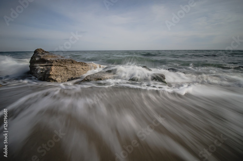 Waves crash into rocks on the beach