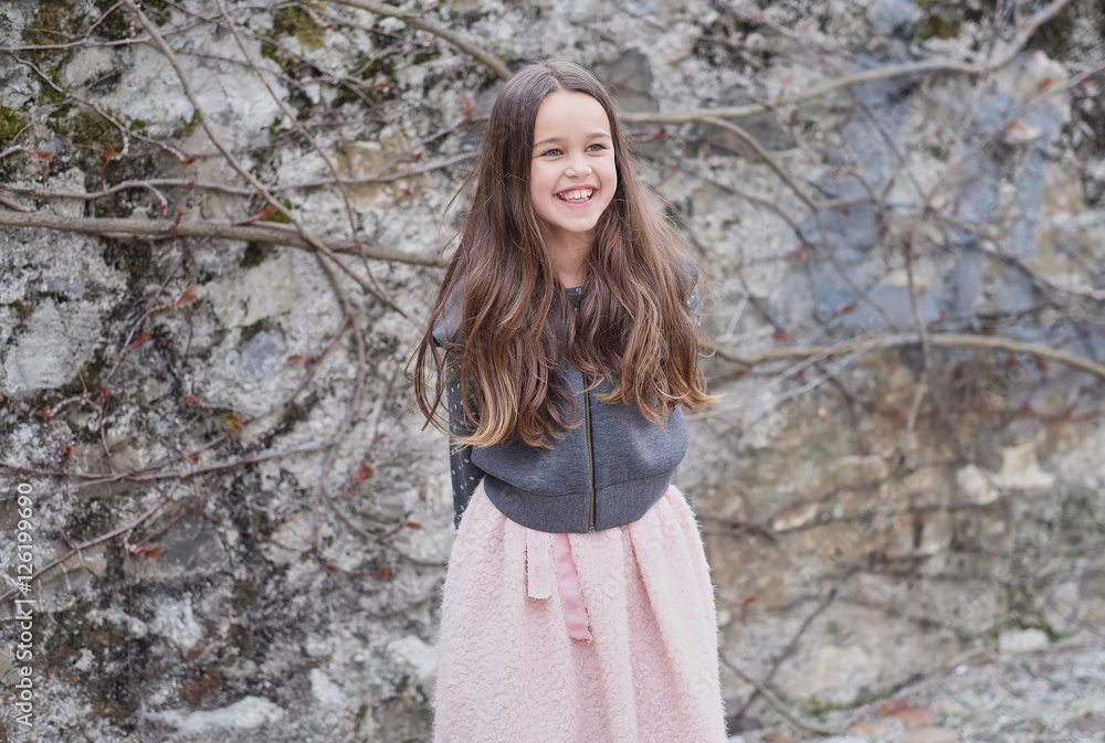 Laughting little girl on grey rock background. Laughting little girl on grey rock background.