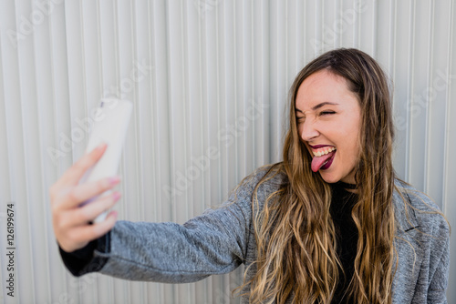 Girl taking selfie with her stick out. photo