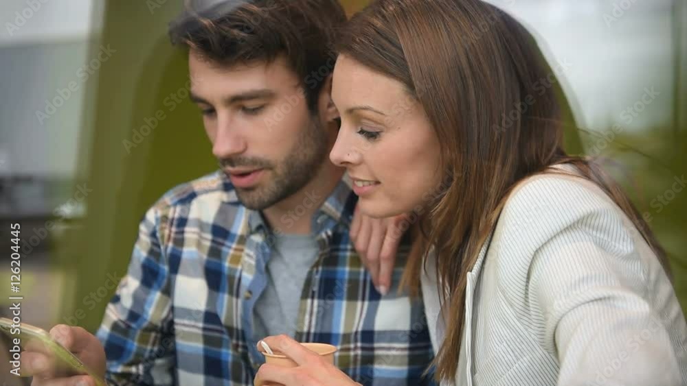 Through-window view of couple sitting in coffee shop Through-window view of couple sitting in coffee shop