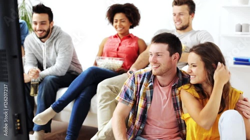 happy friends with popcorn watching tv at home photo