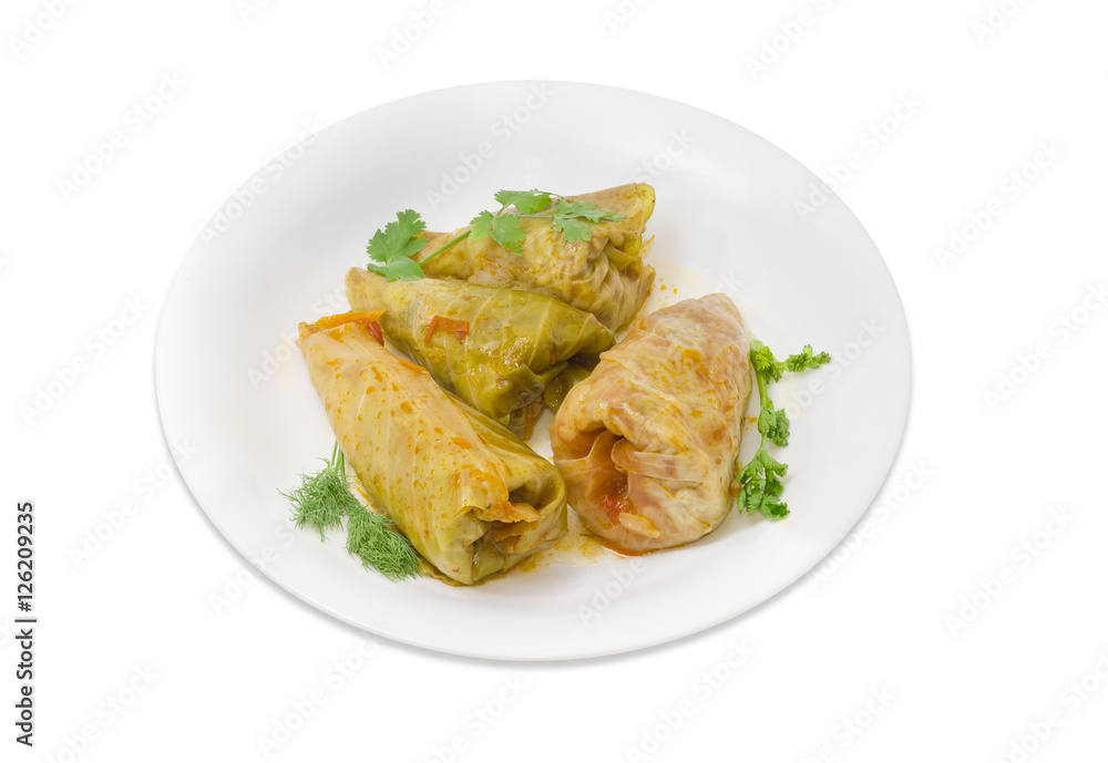 Cooked cabbage rolls and twigs of greenery on white dish Cooked cabbage rolls and twigs of greenery on white dish