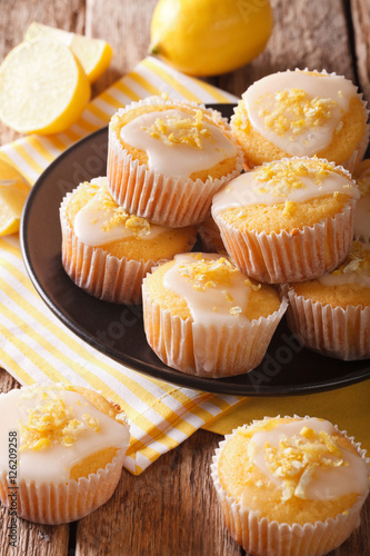 Delicious freshly baked homemade lemon muffins zest sprinkles closeup. vertical