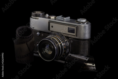 Old photographic camera and photographic films on a dark background