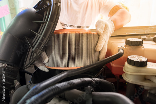 auto mechanic removing air filter for cleaning