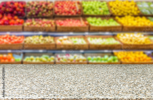 Marble empty table in front of blurred supermarket fruits shelf