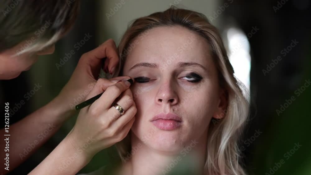 Make-up artist applying makeup to the model Make-up artist applying makeup to the model