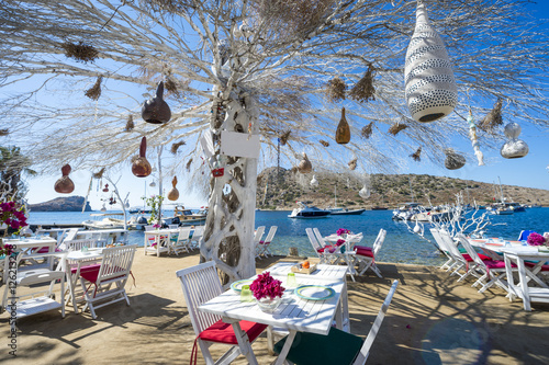 Fototapeta Naklejka Na Ścianę i Meble -  Informal beachside seating with decorative tree in a scenic tourist village near Bodrum, Turkey