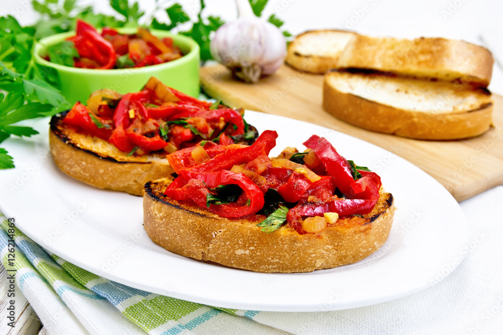 Bruschetta with vegetables in plate on light board