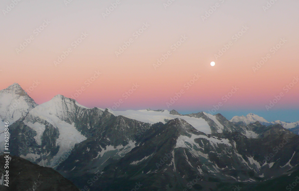 sunrise in the Swiss Alps with a full moon