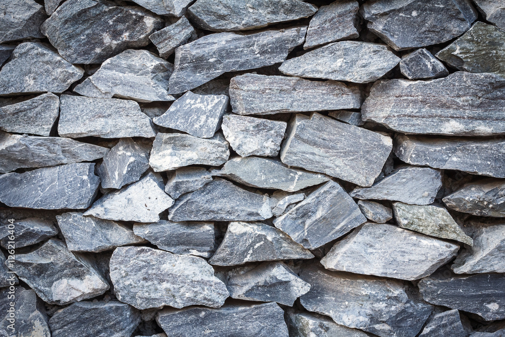 Fototapeta premium Stone texture or stone background. Closeup natural stone wall detail for design with copy space for text or image. Abstract natural stone wall.