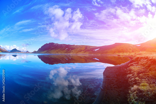 Lake coast with mountain reflection at the sunrise, Iceland