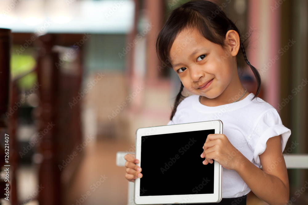 Happy child playing tablet or small computer at home.Black blan Happy child playing tablet or small computer at home.Black blan