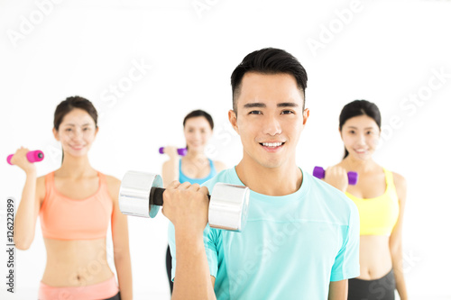 smiling young fit group stretching in gym