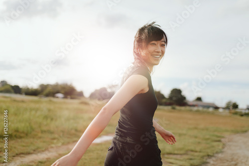 Woman runner walking on field in morning