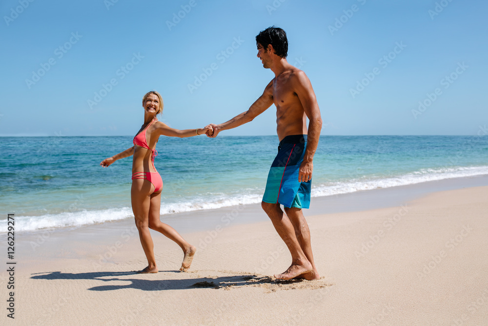 Romantic couple walking on beautiful tropical beach