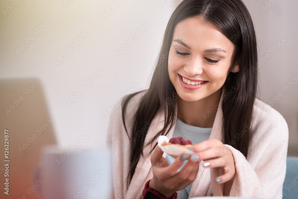 Beautiful young woman enjoying a fruity cupcake. Beautiful young woman enjoying a fruity cupcake.