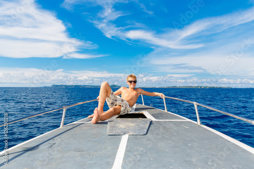 Happy teen boy in sunglasses on the yacht. Tropical sea  © frolova_elena