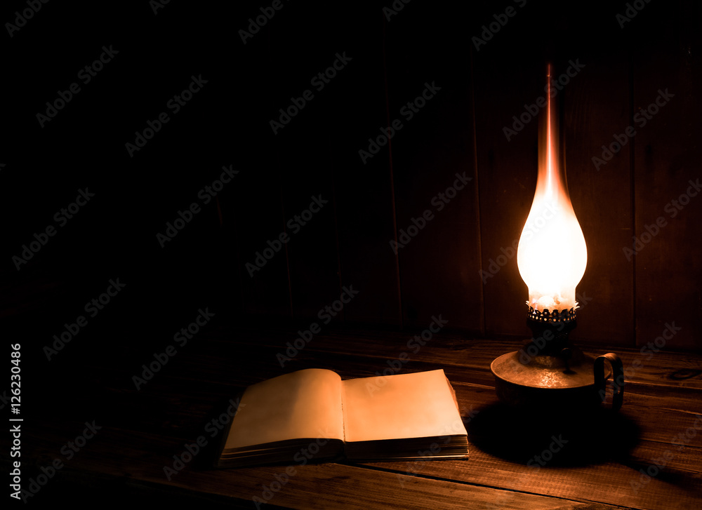 Old antique books with burning paraffin lamp near on the wooden table.  Blank page foto de Stock | Adobe Stock