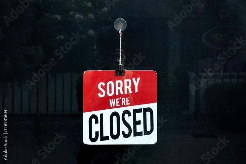 Closed sign in a shop window sorry we are closed. photo