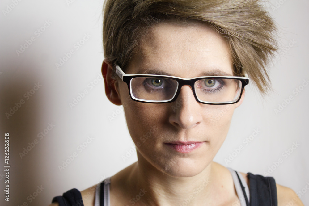 Portrait einer jungen Frau mit kurzen blonden Haare und Brille Portrait einer jungen Frau mit kurzen blonden Haare und Brille