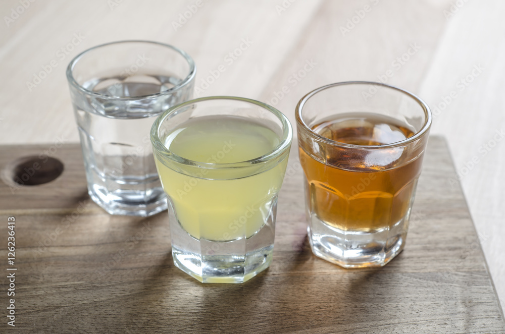 Glass of alcohol on wooden background Glass of alcohol on wooden background