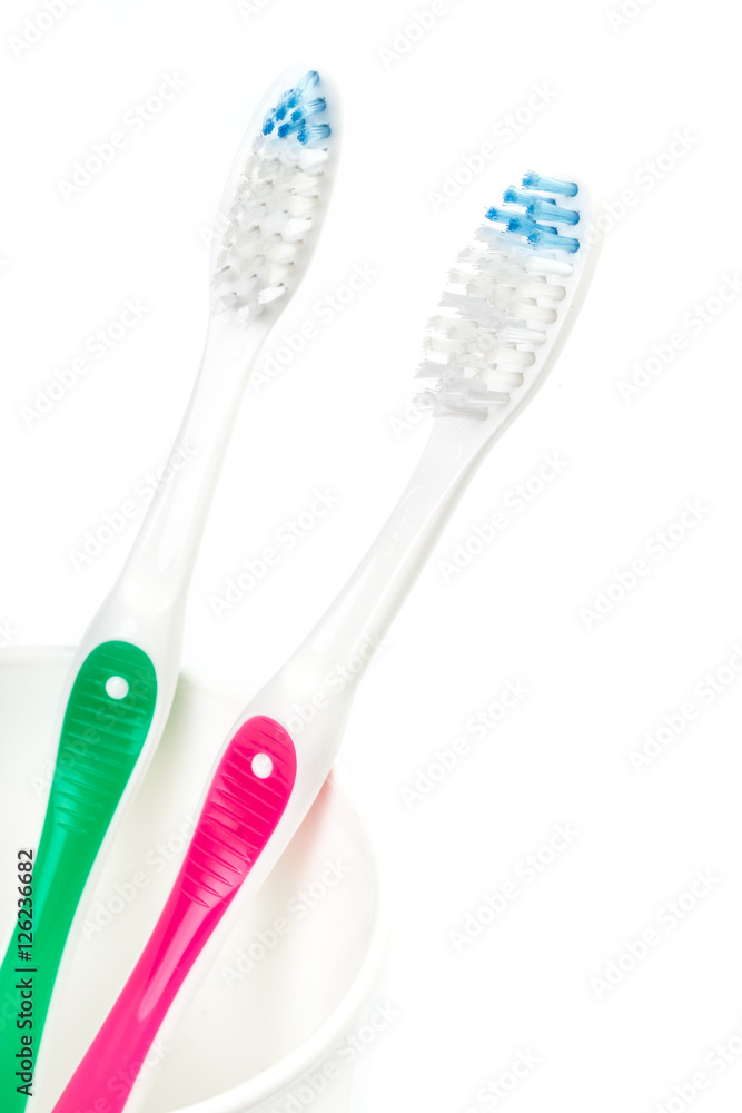 Toothbrushes in glass on table on light background Toothbrushes in glass on table on light background