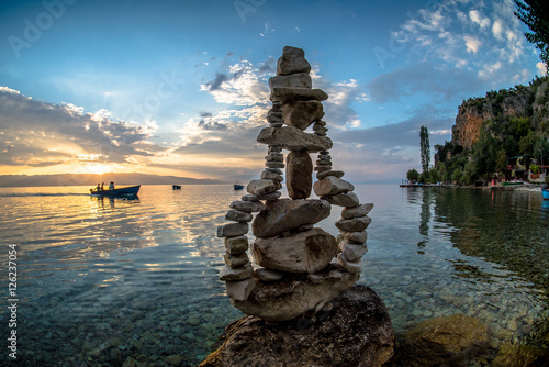 Pear like stone sculpture on sunset by the Ohrid lake photo