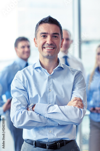 smiling businessman with colleagues in office