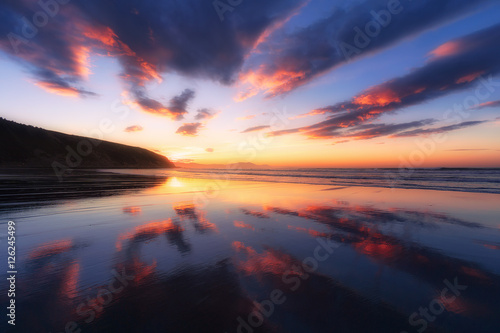 Barinatxe beach with cloud reflections at sunset
