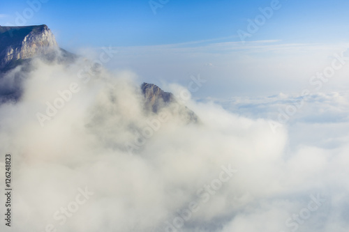 Picturesque view of a layer of white clouds below the mountain peak