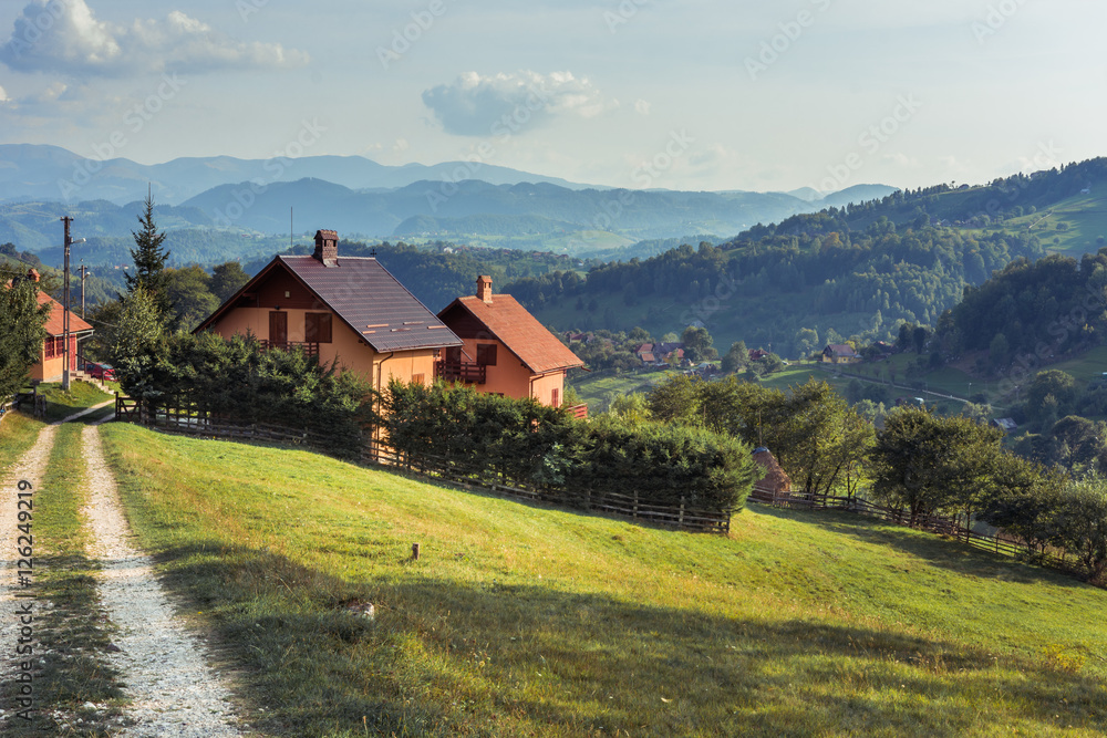 Landscape of Magura village houses and hills with the Carpathian mountains in backgroumd