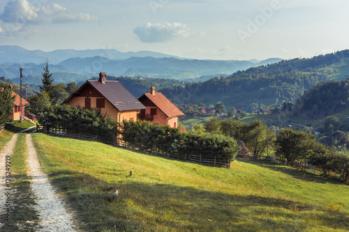 Landscape of Magura village houses and hills with the Carpathian mountains in backgroumd