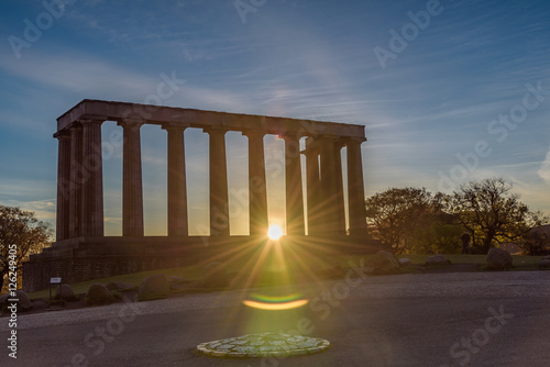 National monument of Scotland at Calton Hill, Edinburgh - beautiful panoramic image at sunrise - sun shining through the columns