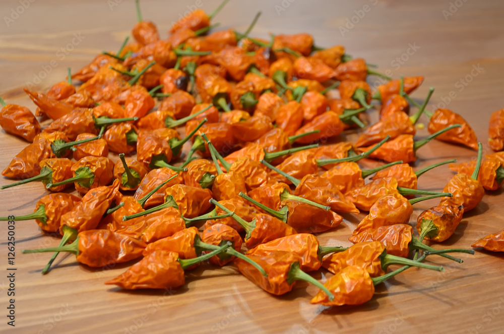 lot of small dried chilli lying on the wood table detail photography lot of small dried chilli lying on the wood table detail photography