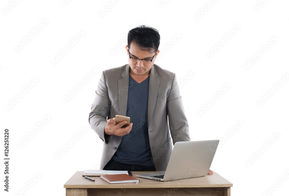 Businessman working on laptop and holding smartphone, white back Businessman working on laptop and holding smartphone, white back