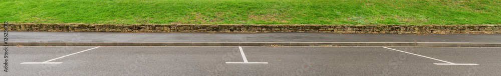 Hintergrund als Panorama zwei leere Parkplätze am Staßenrand mit Gehweg und Gras - Background as a panorama two empty parking places on the roadside with walkway and grass Hintergrund als Panorama zwei leere Parkplätze am Staßenrand mit Gehweg und Gras - Background as a panorama two empty parking places on the roadside with walkway and grass