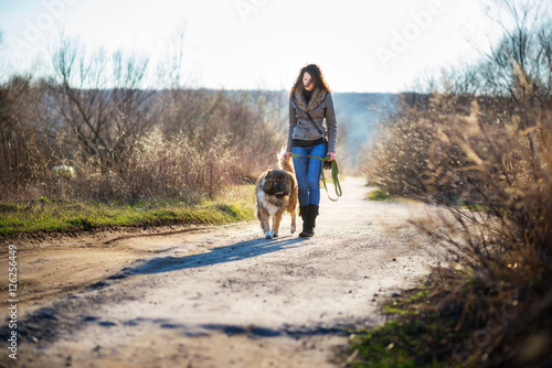 Girl playing with Caucasian shepherd dog, autumn