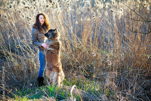 Girl playing with Caucasian shepherd dog, autumn