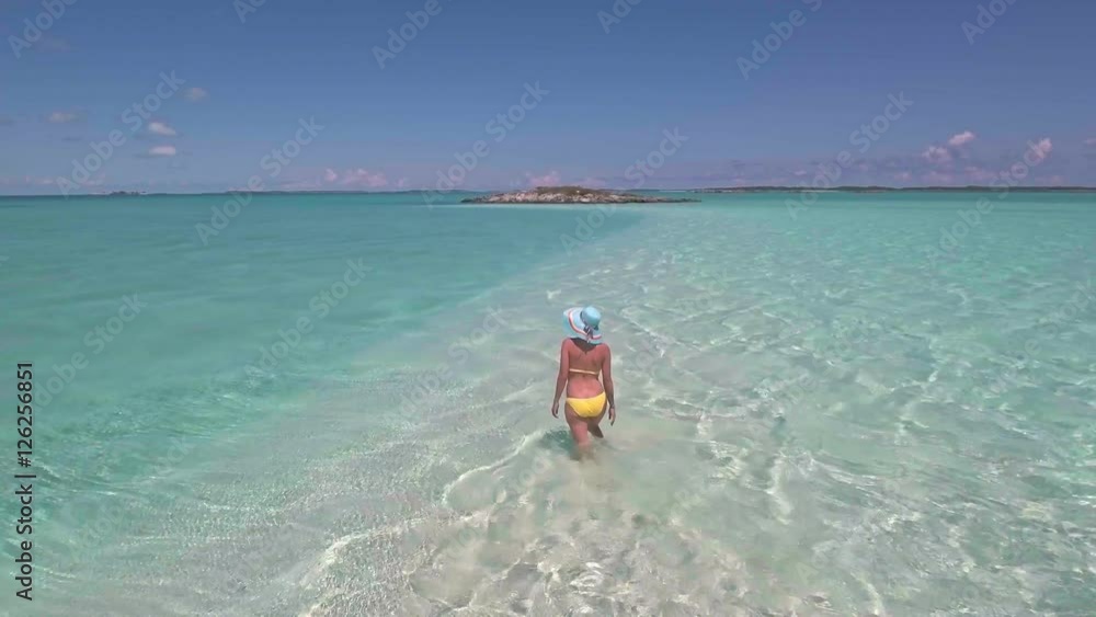 Woman walking on tropical beach. Exuma, Bahamas Woman walking on tropical beach. Exuma, Bahamas